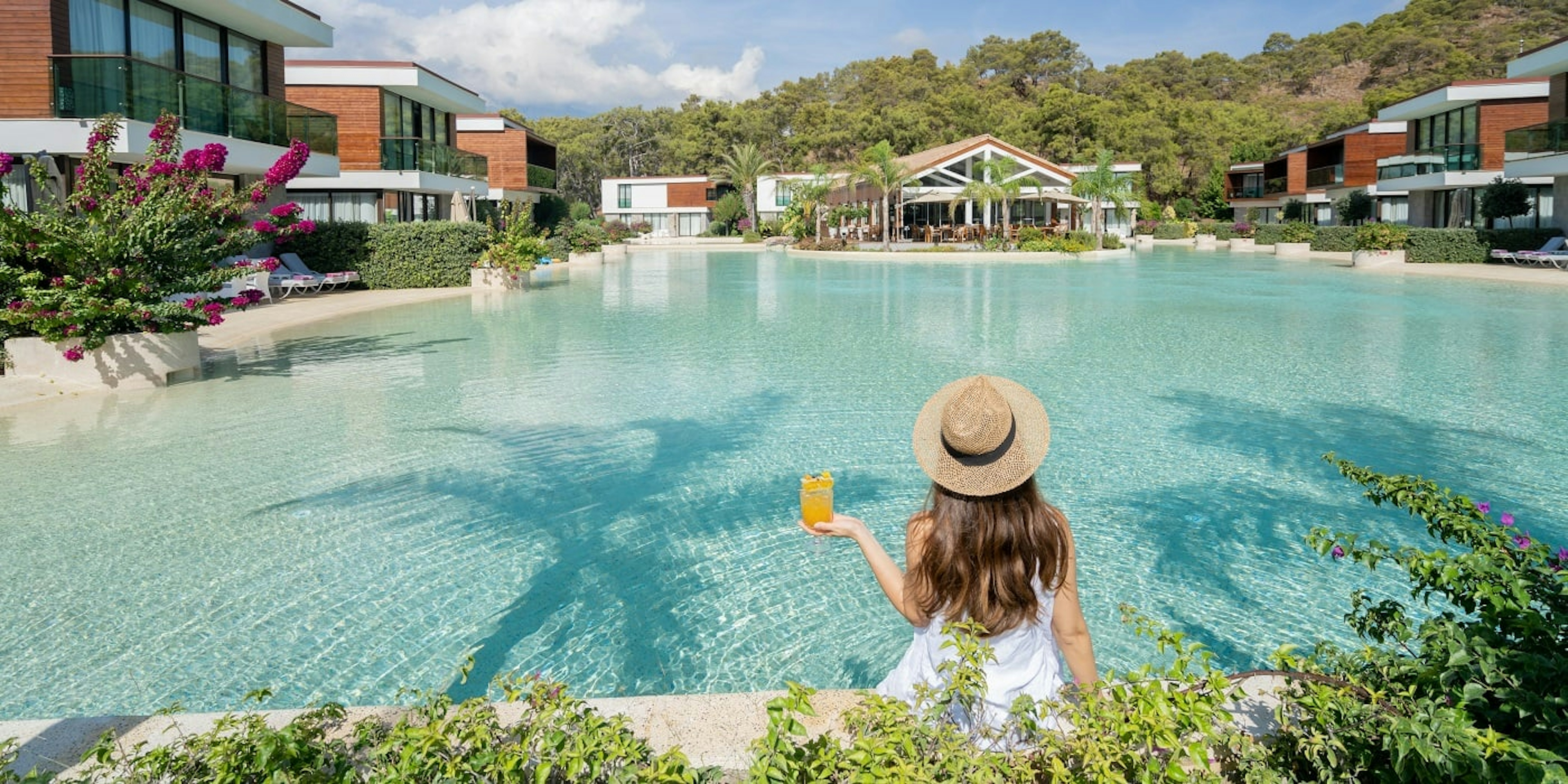 Photo d'une femme avec un verre devant une piscine