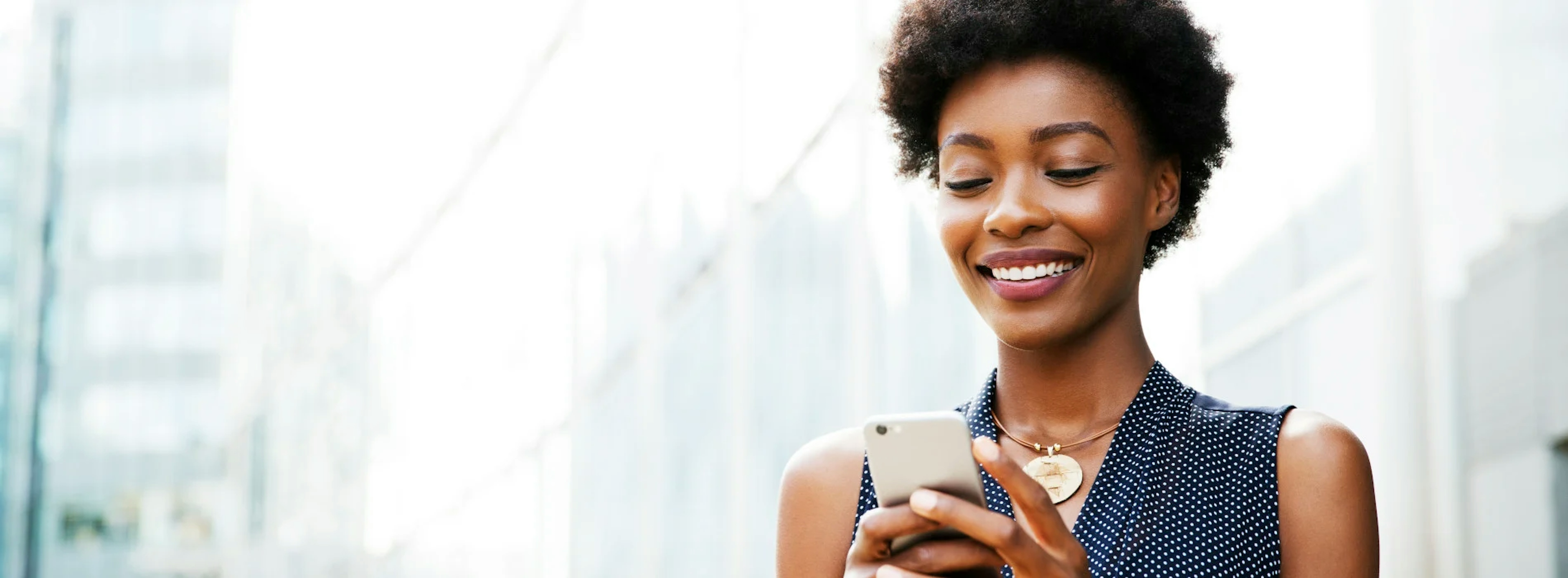 Femme souriante regardant son téléphone